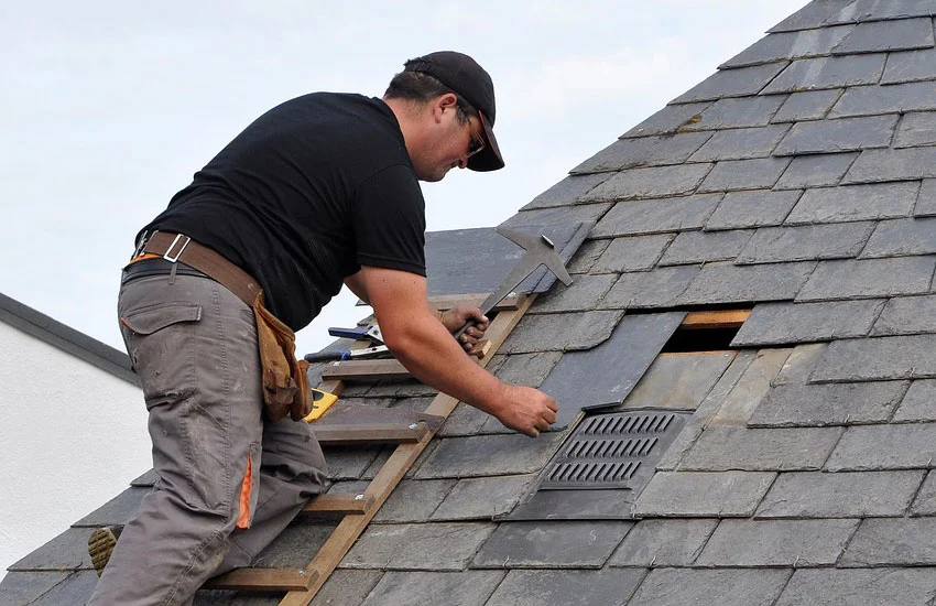 Roofing contractor installing slate tiles
